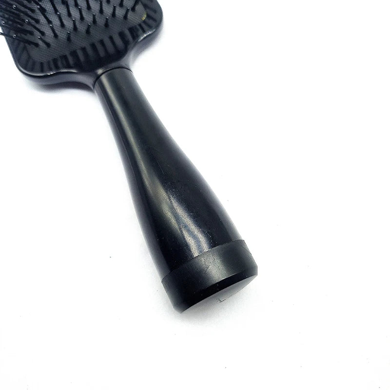 A black hair brush with a tapered handle is shown against a white background.