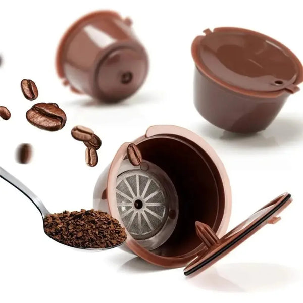 A set of reusable brown coffee capsules and whole coffee beans displayed on a white background.