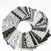 A circular arrangement of square printed cotton fabric packs featuring various black and white patterns.