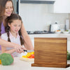 A wooden magnetic knife block organizer is shown on a kitchen counter with fresh vegetables.