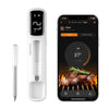 A white mini Bluetooth meat thermometer with an LED display next to a smartphone showing a cooking temperature.