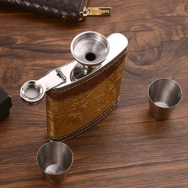 A portable stainless steel hip flask with a hinged lid is shown resting on a wooden surface.