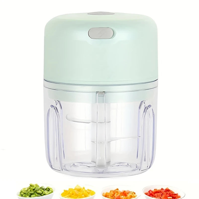 A clear plastic mini rechargeable garlic chopper and meat grinder with a light green lid and multiple blades.