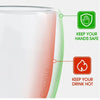 A close-up view of a clear glass mug with a light pink tint, featuring safety icons for keeping hands safe and drinks hot.