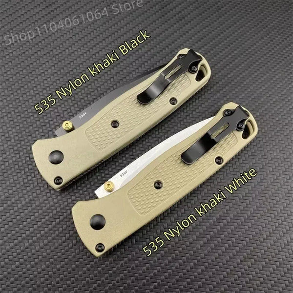 Ein Paar 535 Nylon faltbare Multitools in Khaki, Schwarz und Weiß mit schwarzen Griffen auf einer dunklen Oberfläche.