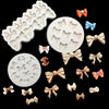 A collection of silicone baking molds in various shapes and colors including bows and flowers.