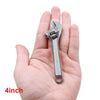 A hand holds a silver compact mini adjustable spanner wrench tool.