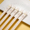 A set of reusable multi-color chopsticks with delicate floral patterns resting on a white plate.