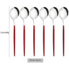 A set of six white and black dinner spoons with red handles.