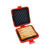 Orange sandwich maker with a black grill plate and a toasted sandwich inside