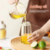 A hand pours cooking oil from a glass measuring cup into a bottle, demonstrating how to add oil to prevent leakage.