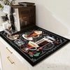 A dark mat featuring a coffee theme is placed under a modern coffee machine.