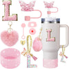 A pink tumbler accessory kit featuring a silicone boot, straw covers, and charm with a large letter L design.