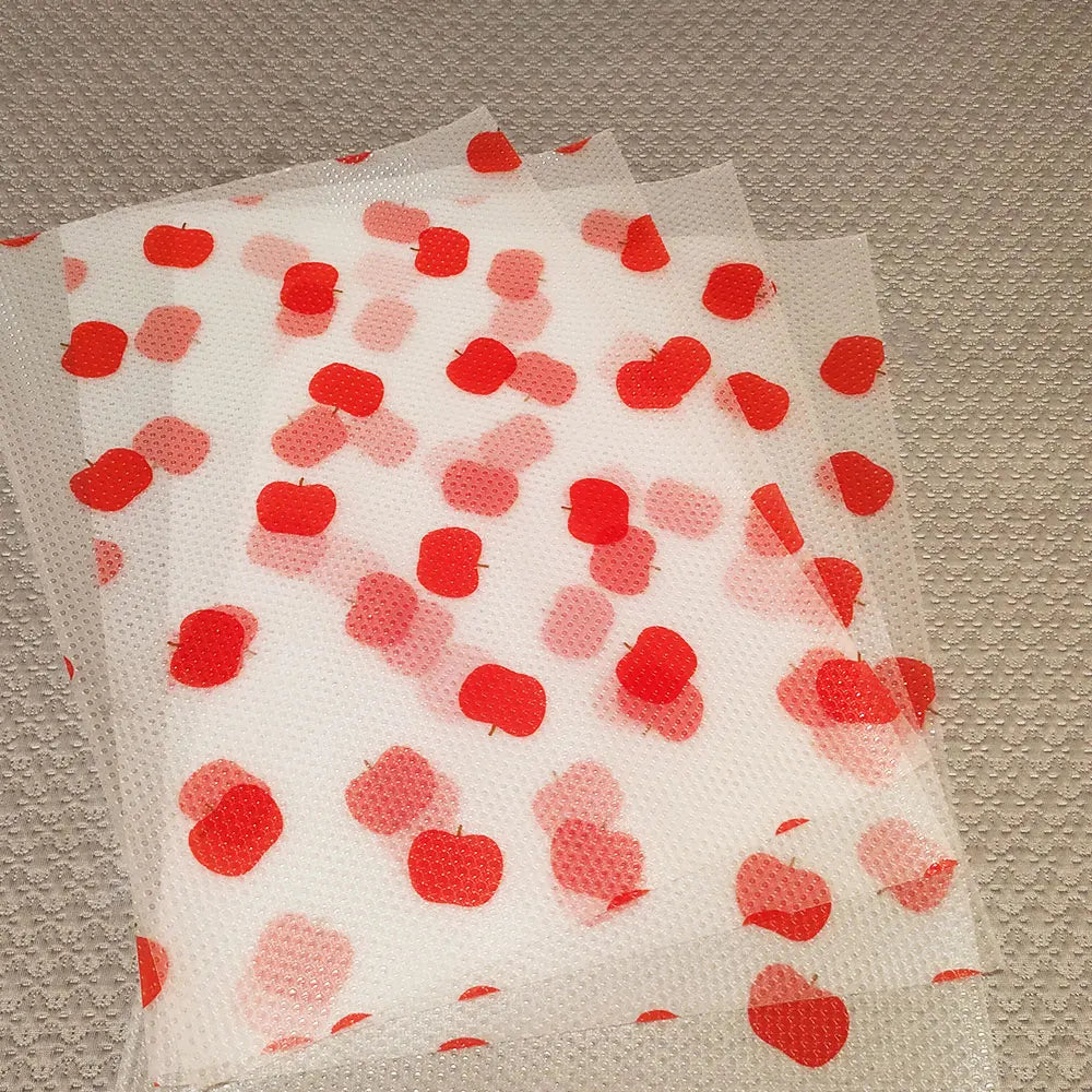 Confeti rojo y rosa esparcido sobre un forro de estante impermeable de EVA transparente.