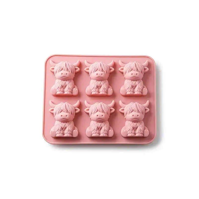 A silicone mold tray containing six pink, elephant-shaped ice cube molds.