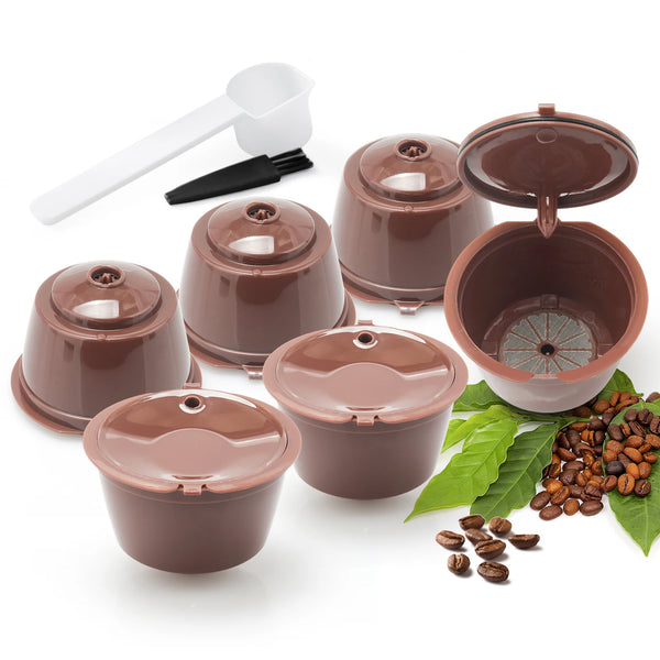 A set of reusable brown coffee capsules and a white tamper are displayed on a white background.