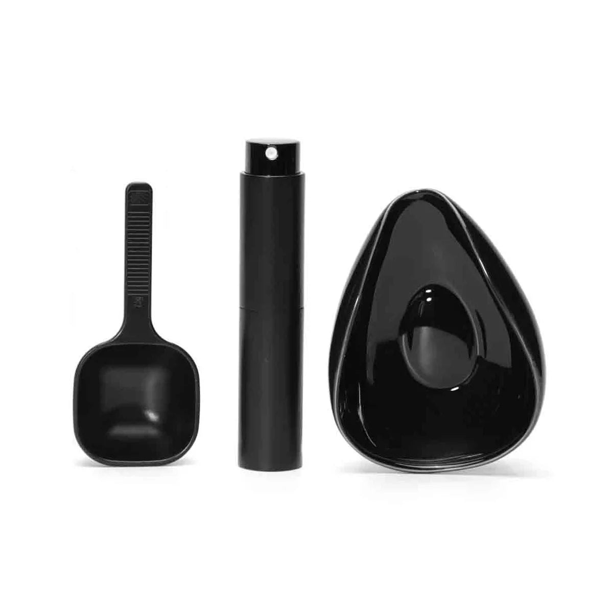 Black ceramic coffee dosing and spray kit with a spoon and a bottle.