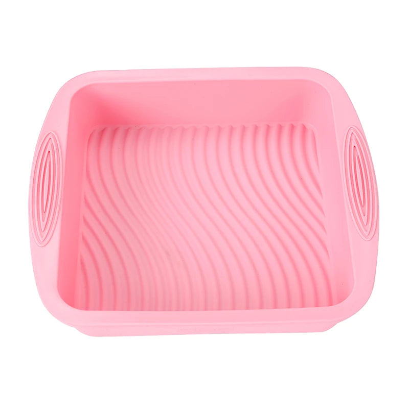 A pink nonstick silicone baking set with a square pan and surrounding ridges.