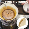 A close-up of fine filtering coffee grounds being poured into a reusable cone coffee filter for a safe and healthy brew.