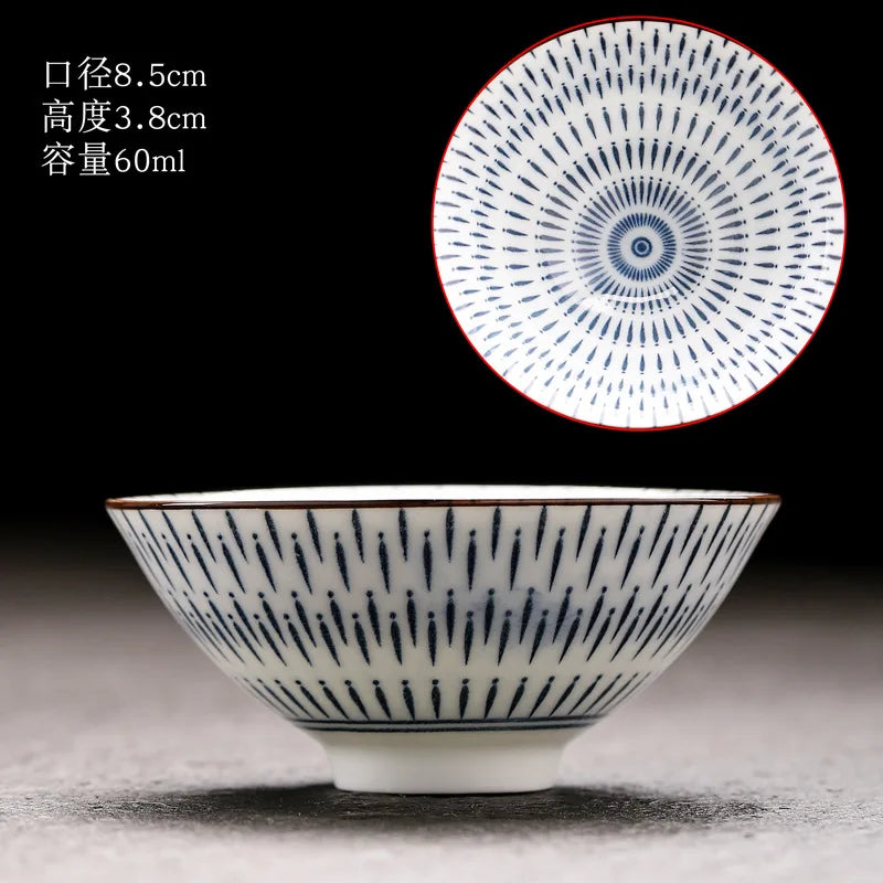 A white porcelain bowl with blue speckles is shown next to a circular decorative plate.
