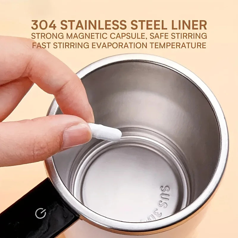 A hand is stirring a stainless steel coffee cup with a magnetic capsule for automatic stirring.