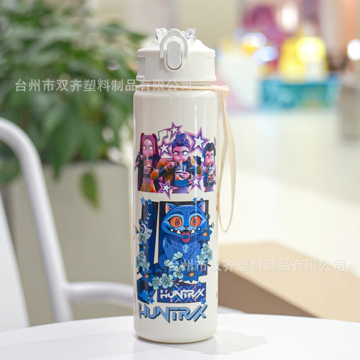 A white insulated water cup with a cartoon print featuring several stylized characters and blue accents.
