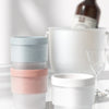 A stack of four food-grade ice molds in pastel colors, including light blue, mint green, pale gray, and blush pink.