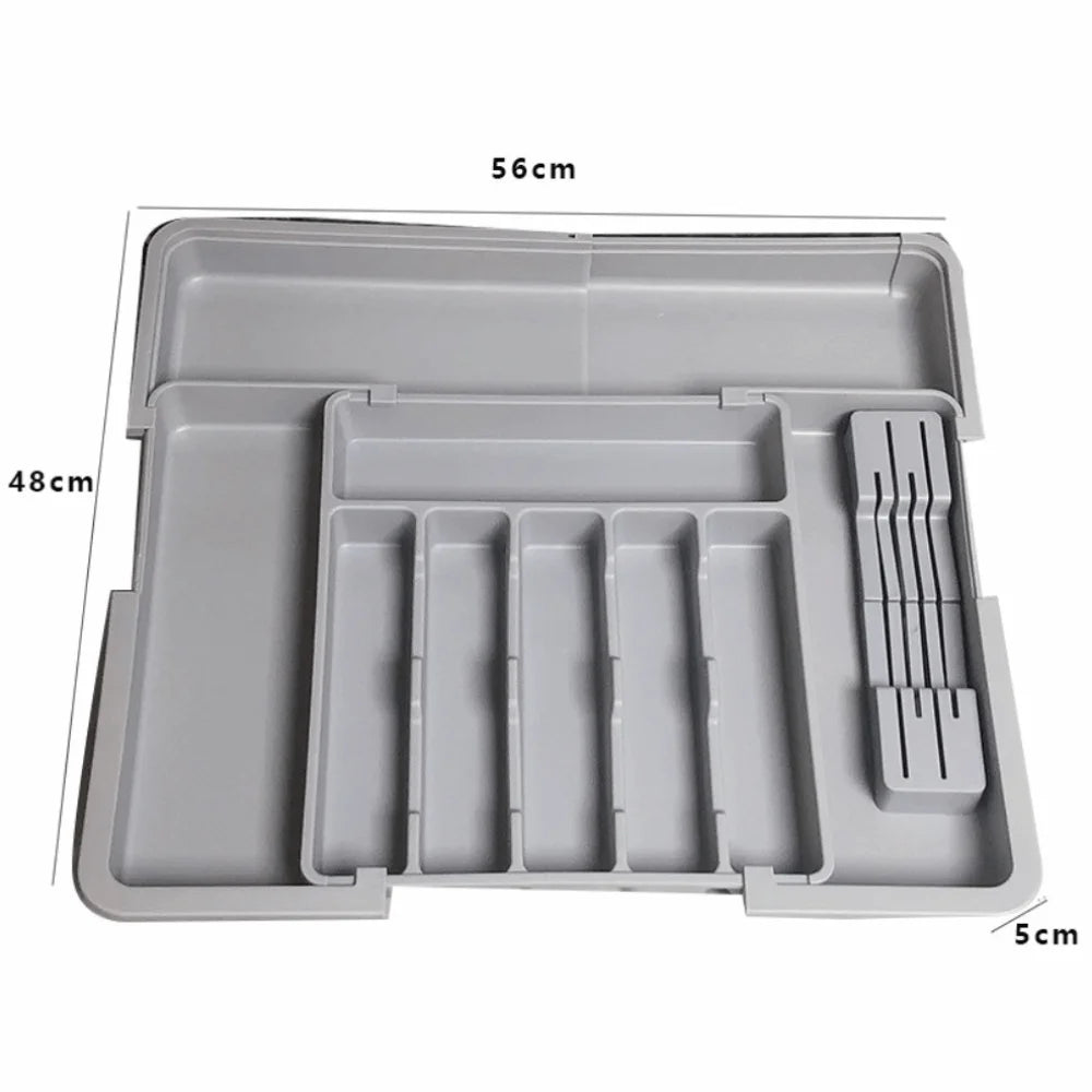 A gray retractable cutlery drawer organizer tray with multiple compartments and a slotted utensil holder.