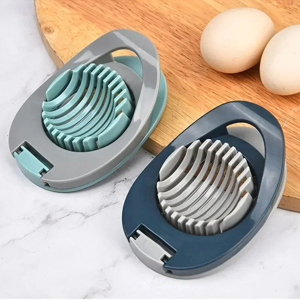 Grau-blauer multifunktionaler Edelstahl-Eier-Slicer mit kreisförmiger Schneidplatte auf Holzbrett neben Eiern.