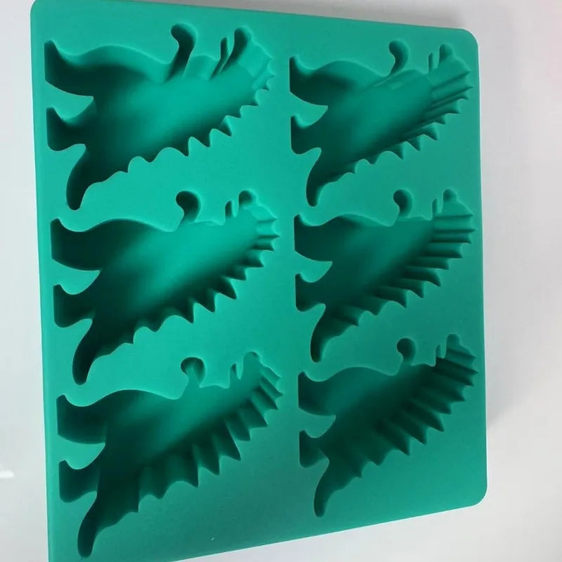 A green silicone ice cube tray set with dinosaur shaped molds.