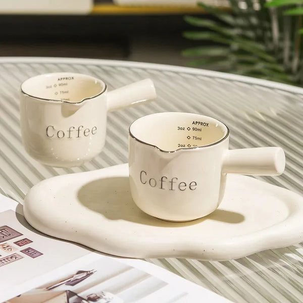 Weißer Keramikkaffeetasse-Set mit passender Untertasse und kleiner Informationskarte.