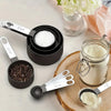 A precision stainless steel measuring set with spoons and containers for measuring ingredients on a light surface.