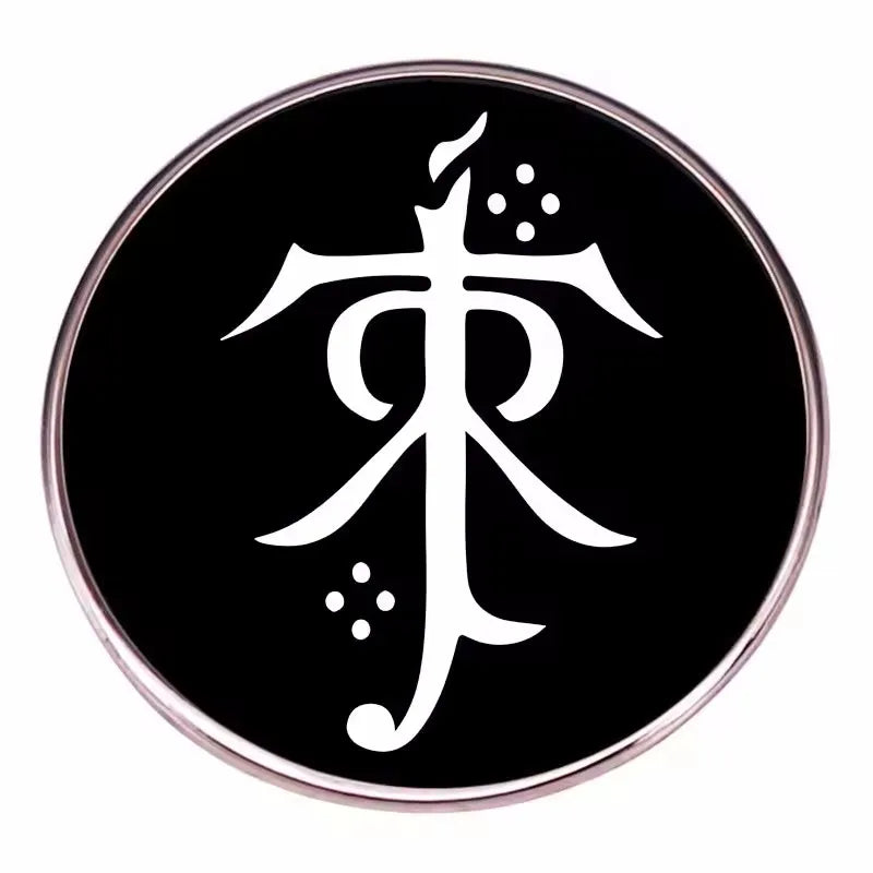 A round black enamel pin featuring a white stylized symbol on a silver-toned metal background.