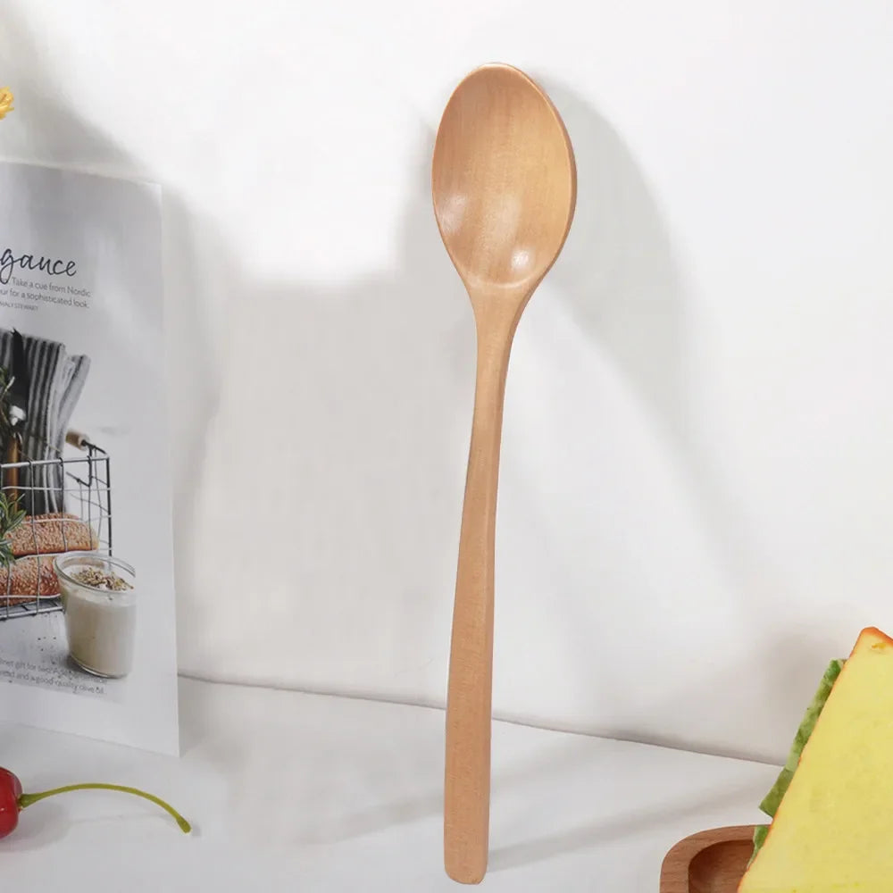 A single light wood spoon is shown against a white background.