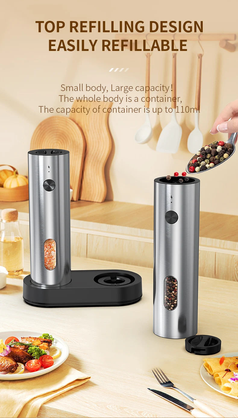 Un moulin à épices argenté rechargeable USB avec une base noire, à côté de diverses épices et aliments.