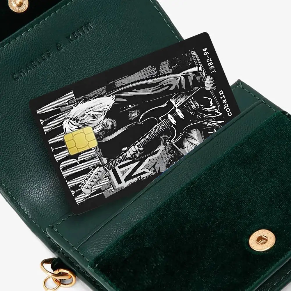 A dark green wallet holds a black debit card featuring an anime-style illustration of a musician.