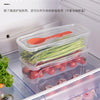A clear plastic storage container holds fresh herbs and vegetables for use with a microwave noodle and salad cooker set.