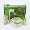 A set of Japanese style matcha bowls and bamboo whisks is displayed in a green box.