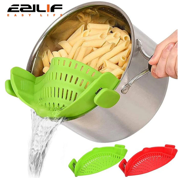 A hand pours water through a green silicone clip-on strainer into a pot of pasta and vegetables.