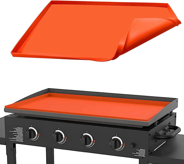 Orangefarzige Silikon-BBQ-Backmatte auf einem schwarzen Grill oder Kochfeld.