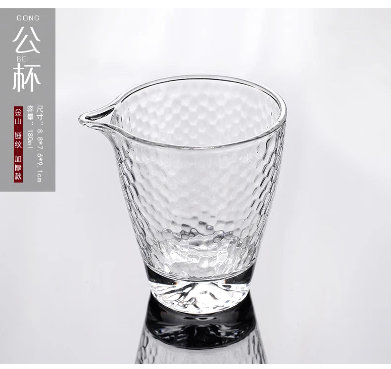 A clear, textured glass teapot or pourer is shown against a white background.