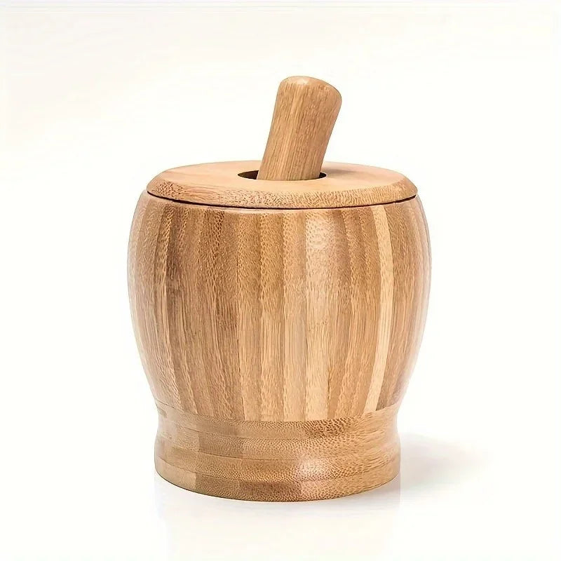 A light brown bamboo mortar and pestle set with a wooden pestle resting on a white surface.