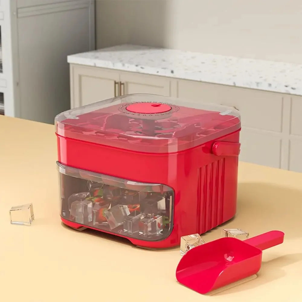 A red refrigerator ice maker with an easy-press lid and a pink spatula is displayed on a light wooden surface.