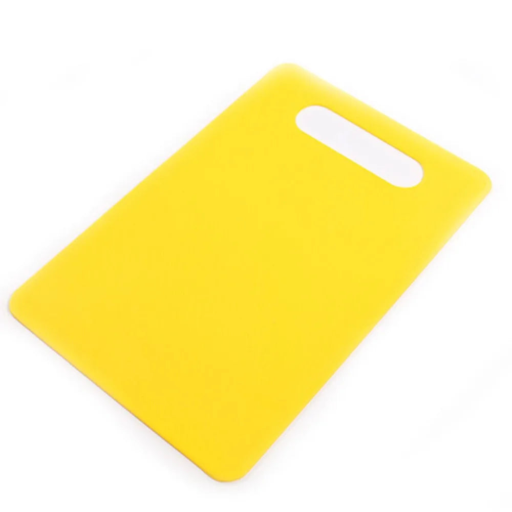 A bright yellow plastic cutting board with a white handle, shown from above.