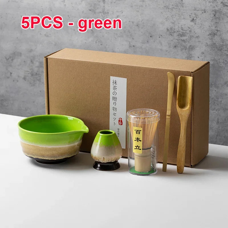 Juego de cinco piezas de té matcha verde con cuencos y utensilios de bambú en caja de cartón.