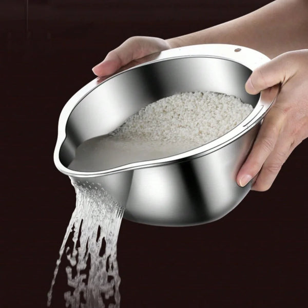 Eine Hand gießt Wasser aus einer Edelstahl-Reiswaschschüssel und einem Sieb.