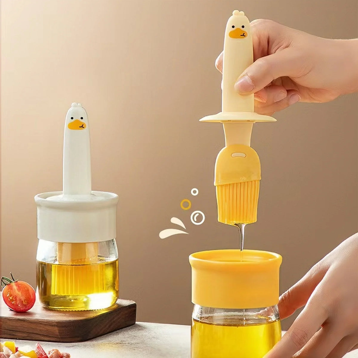 A hand is pouring golden oil from a silicone dispenser bottle into another glass container.