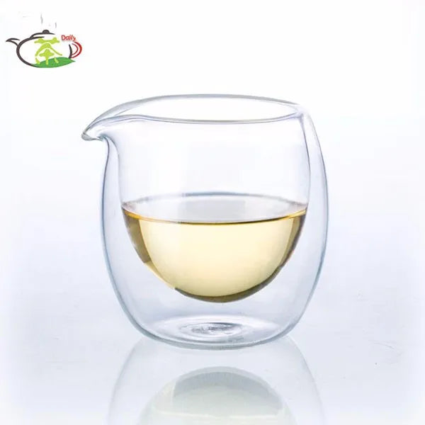 A clear double-wall glass tea pitcher filled with light yellow liquid, shown against a white background.
