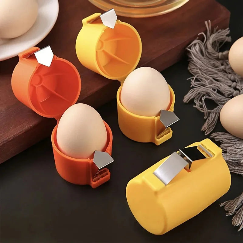 A set of yellow and orange manual egg shell openers and beaters resting on a dark wooden surface.