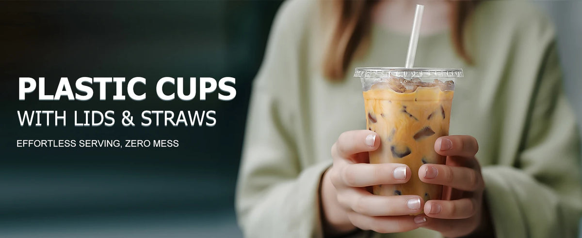 A person holds a clear plastic cup filled with iced coffee, featuring a lid and straw.